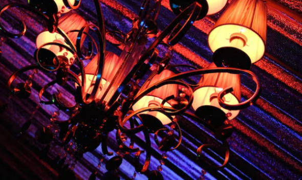 Warm chandelier lighting representing a premium dark visual mood